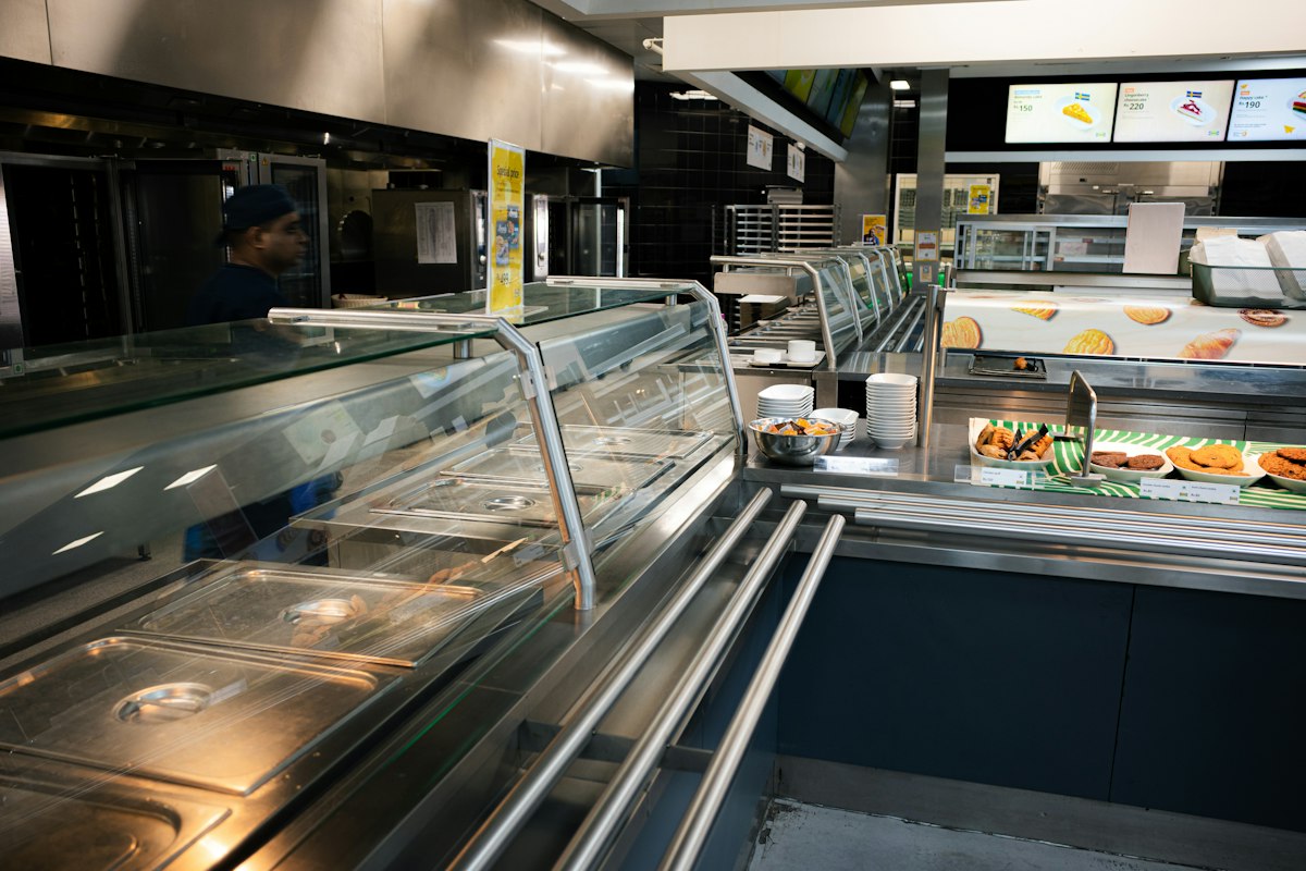 Línea de servicio de una cafetería con vitrinas de comida